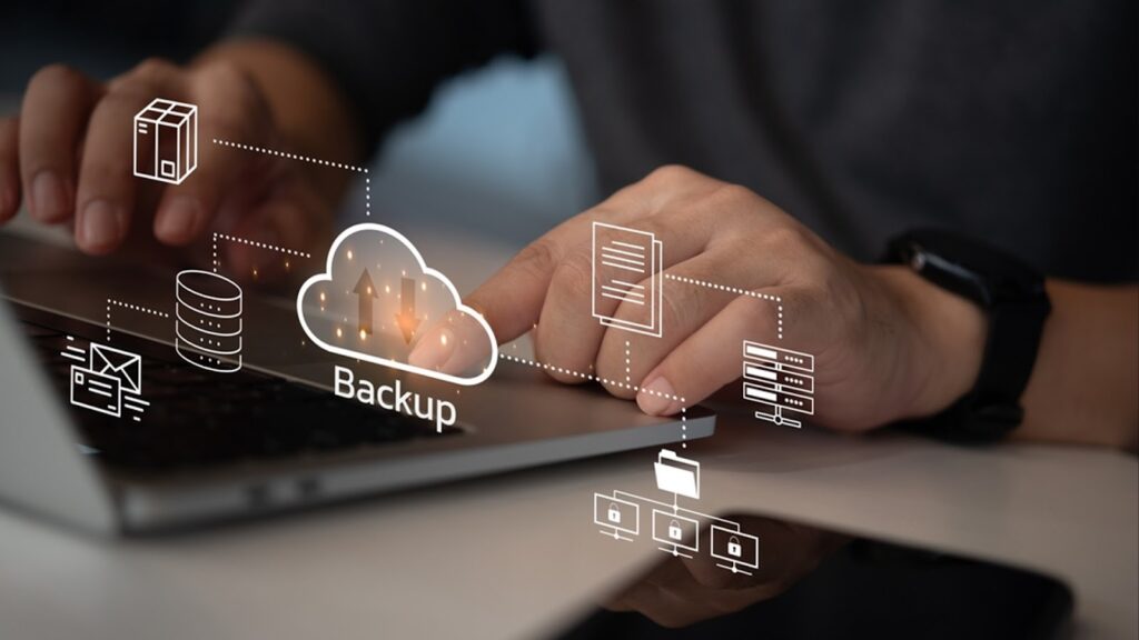 Close-up of hands typing on a laptop keyboard with a digital graphic overlay illustrating cloud backup, data synchronization, and secure file storage networks.
